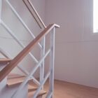 Escalera interior con barandilla de madera y estructura blanca